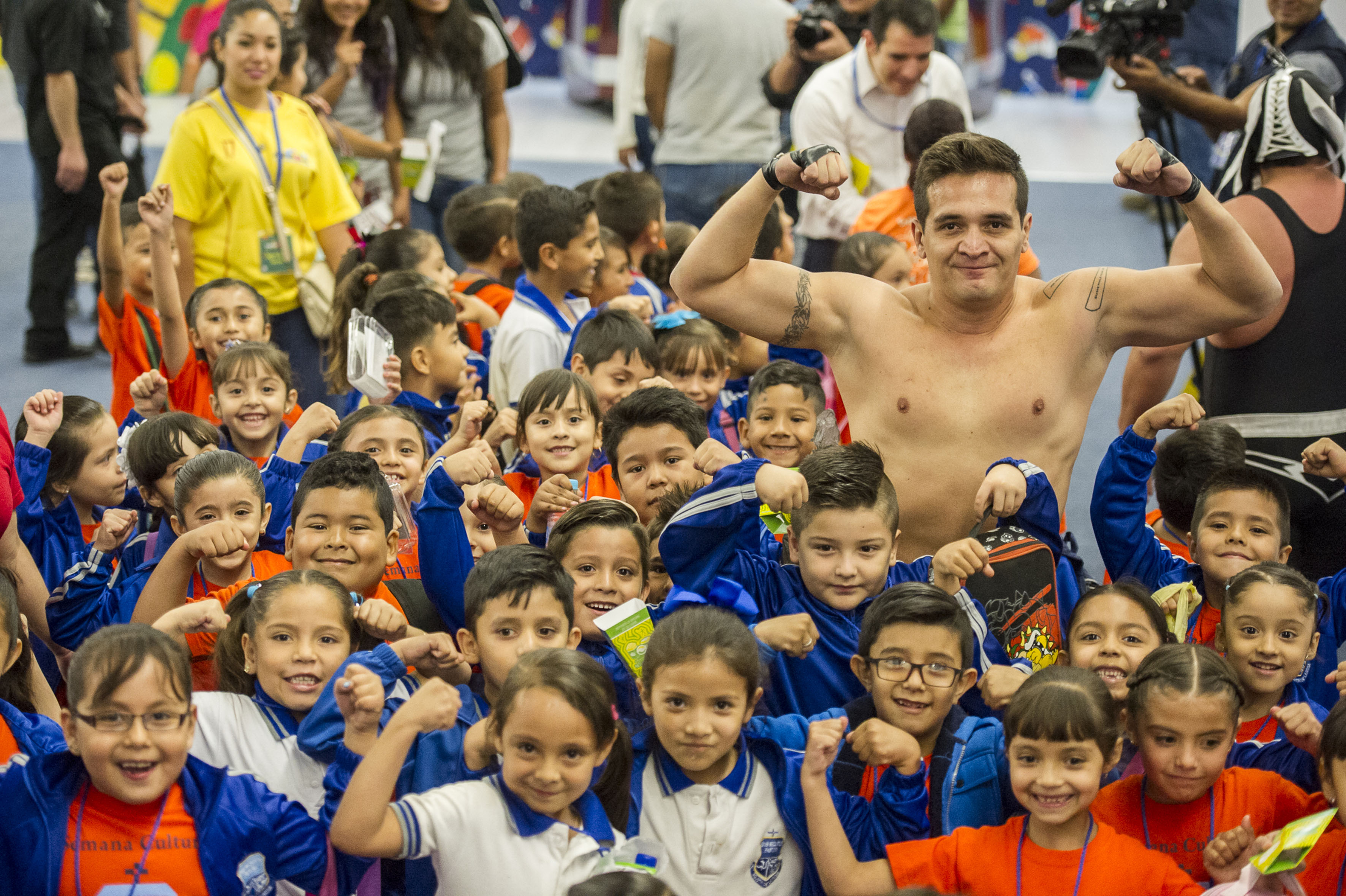 Niños escolares asistentes a Papirolas 2017, alzando sus brazos a lo alto en señal de fuerza, al conjunto e imitación del deportista luchador.