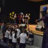 Grupo de niños de escuelas de Autlán y alrededores, disfrutando de un espectáculo de música y de eventos con personajes de un negrito en zancos y un payaso, dentro del auditorio del Centro Universitario.