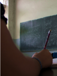 Brazo de estudiante que está tomando apunte del pizarrón