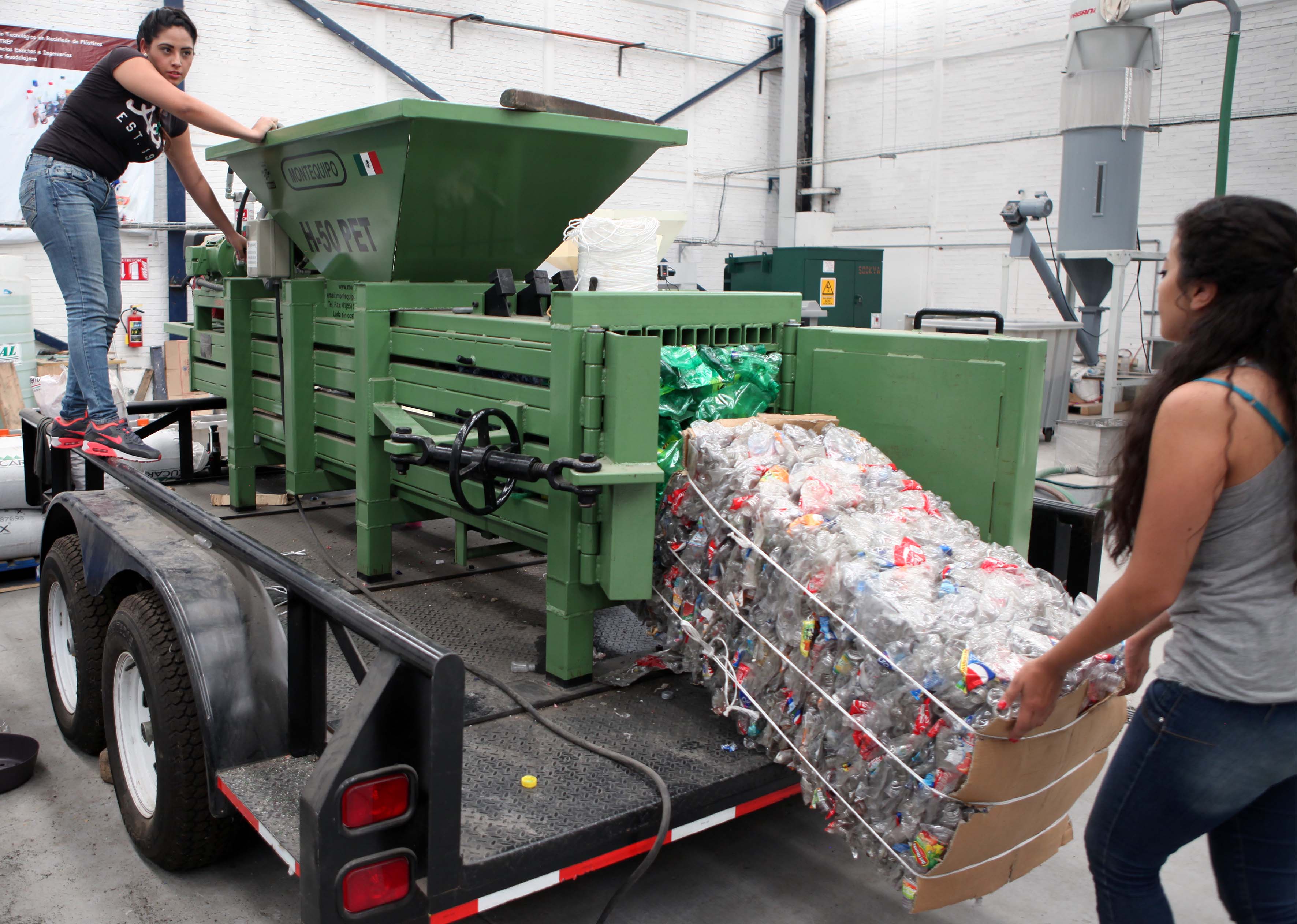 Mujer depositando botellas de plástico en maquina de reciclado