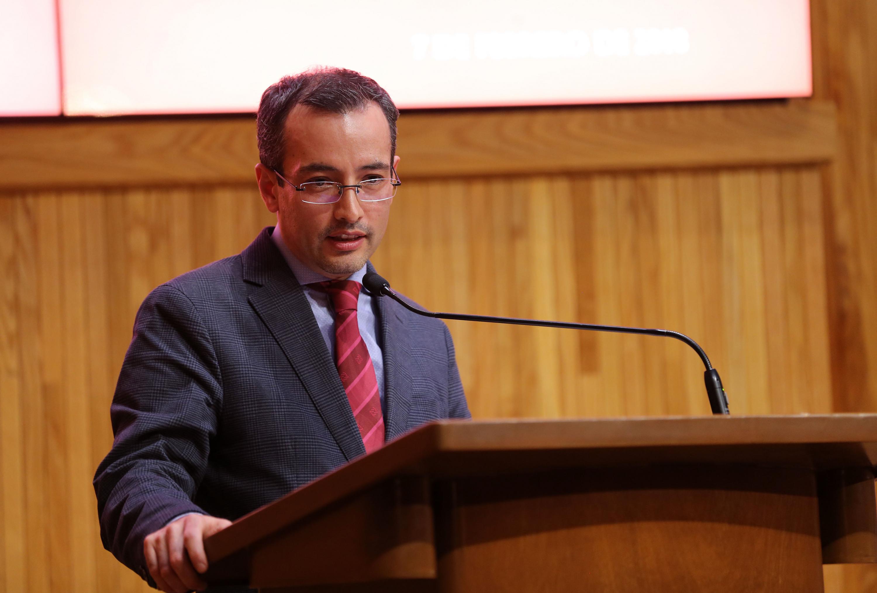 El doctor Moreno al micrófono del podium inaugurando la conferencia