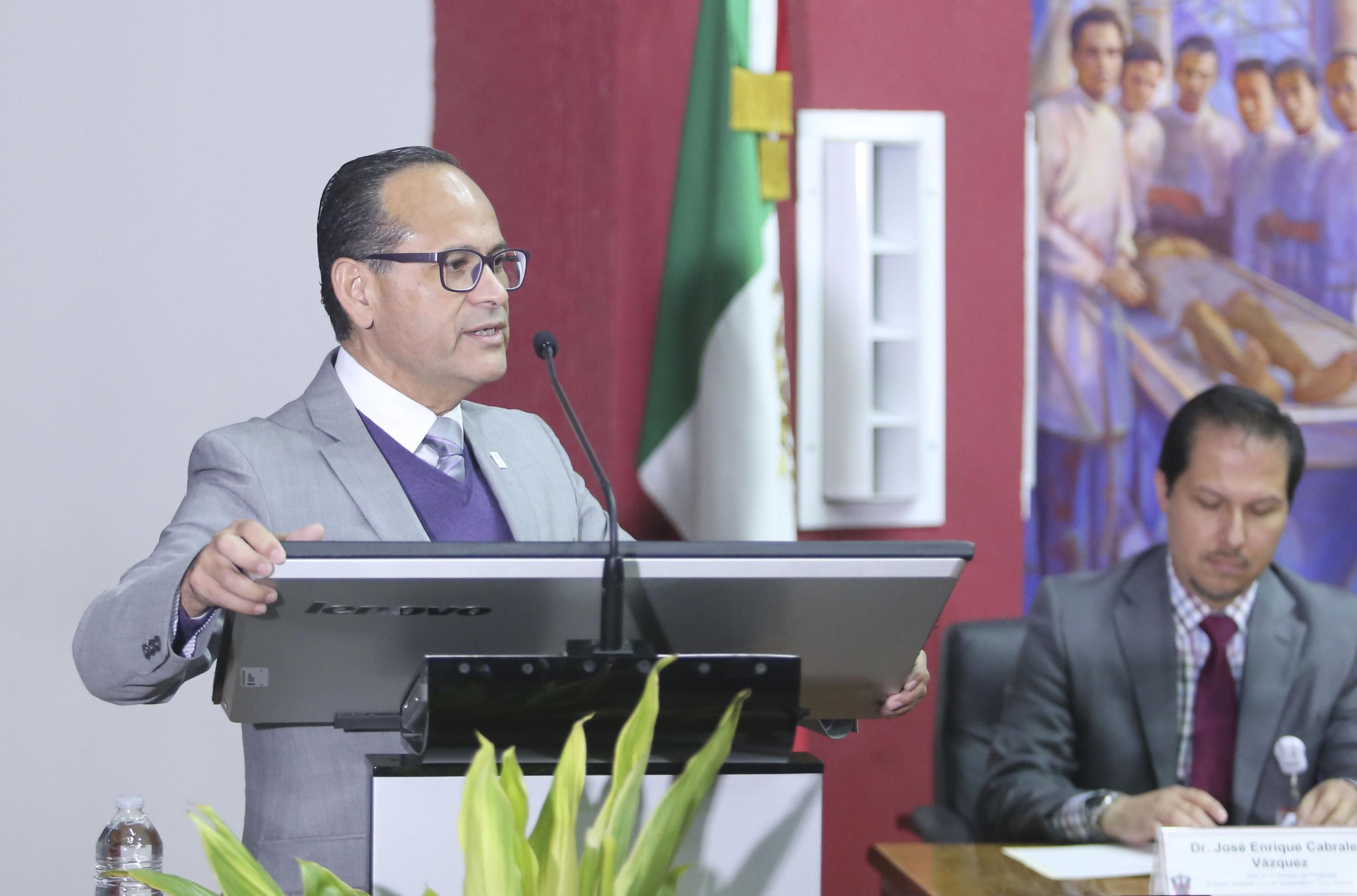 El doctor Pérez hablando desde el podium en el acto académico