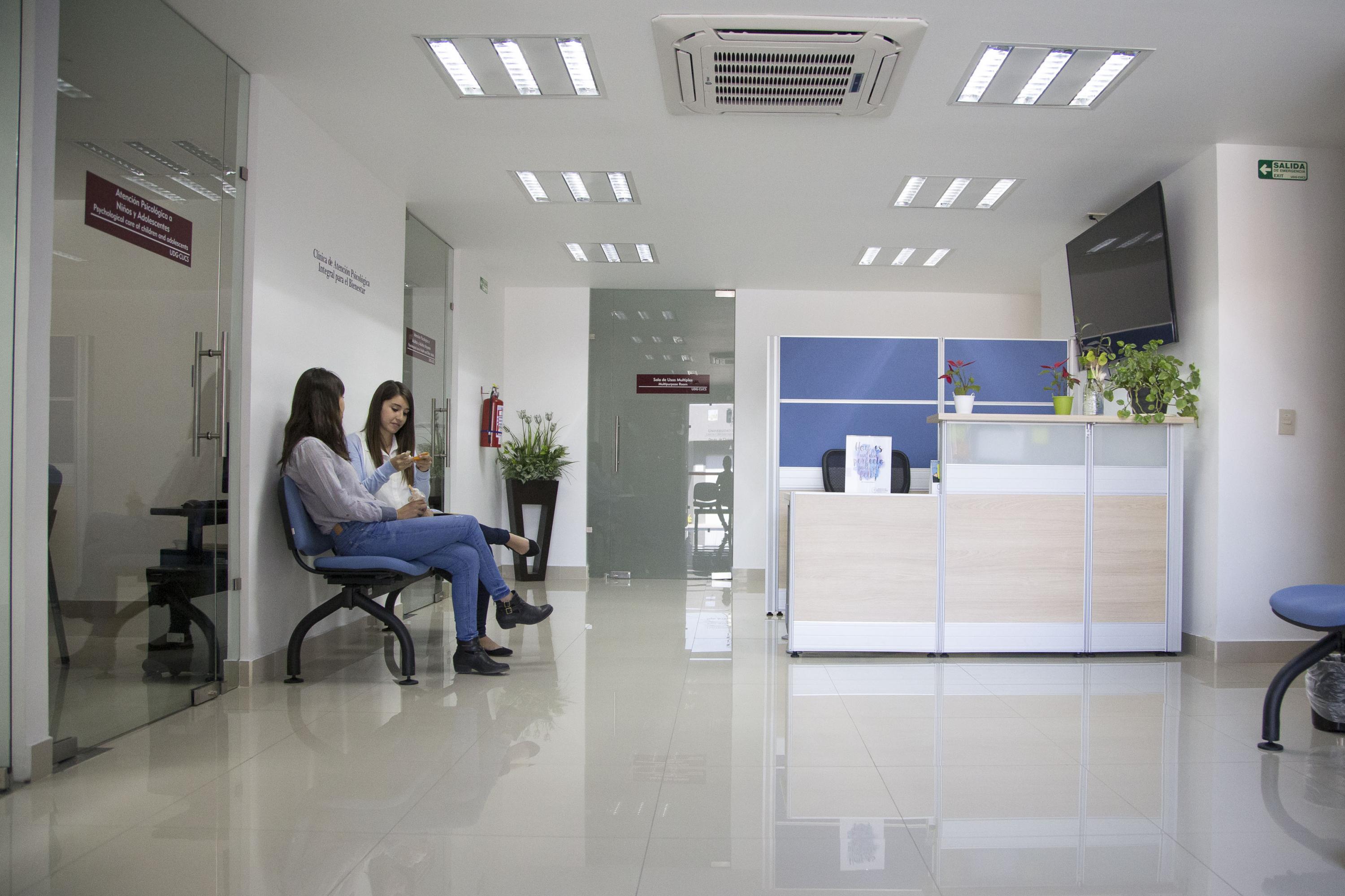 Sala de espera del CAPIB CUCS en donde hay dos mujeres jovenes sentadas conversando