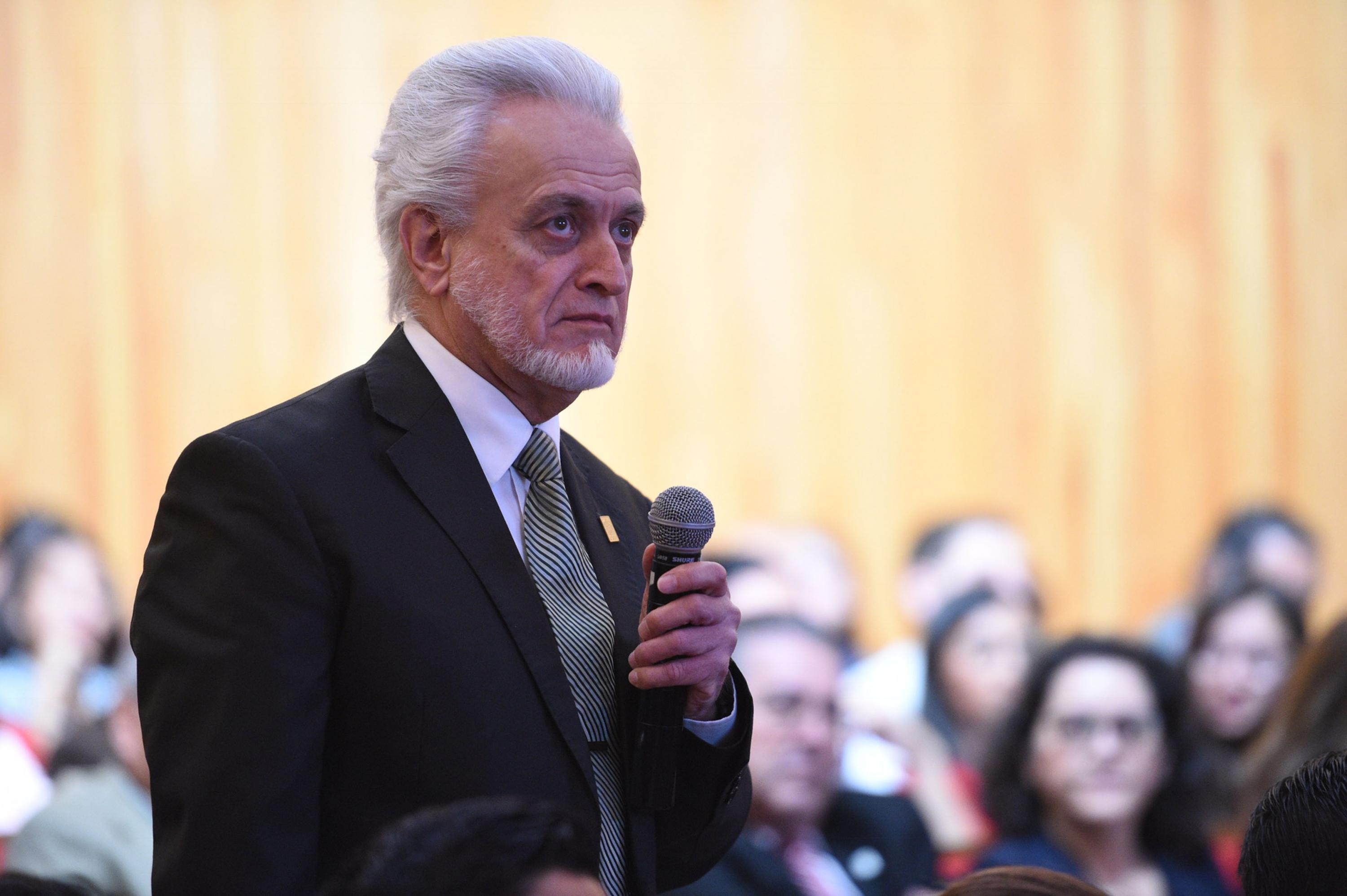 Maestro José Manuel Jurado Parres, director de la Preparatoria número 5, con micrófono en mano haciendo uso de la voz.