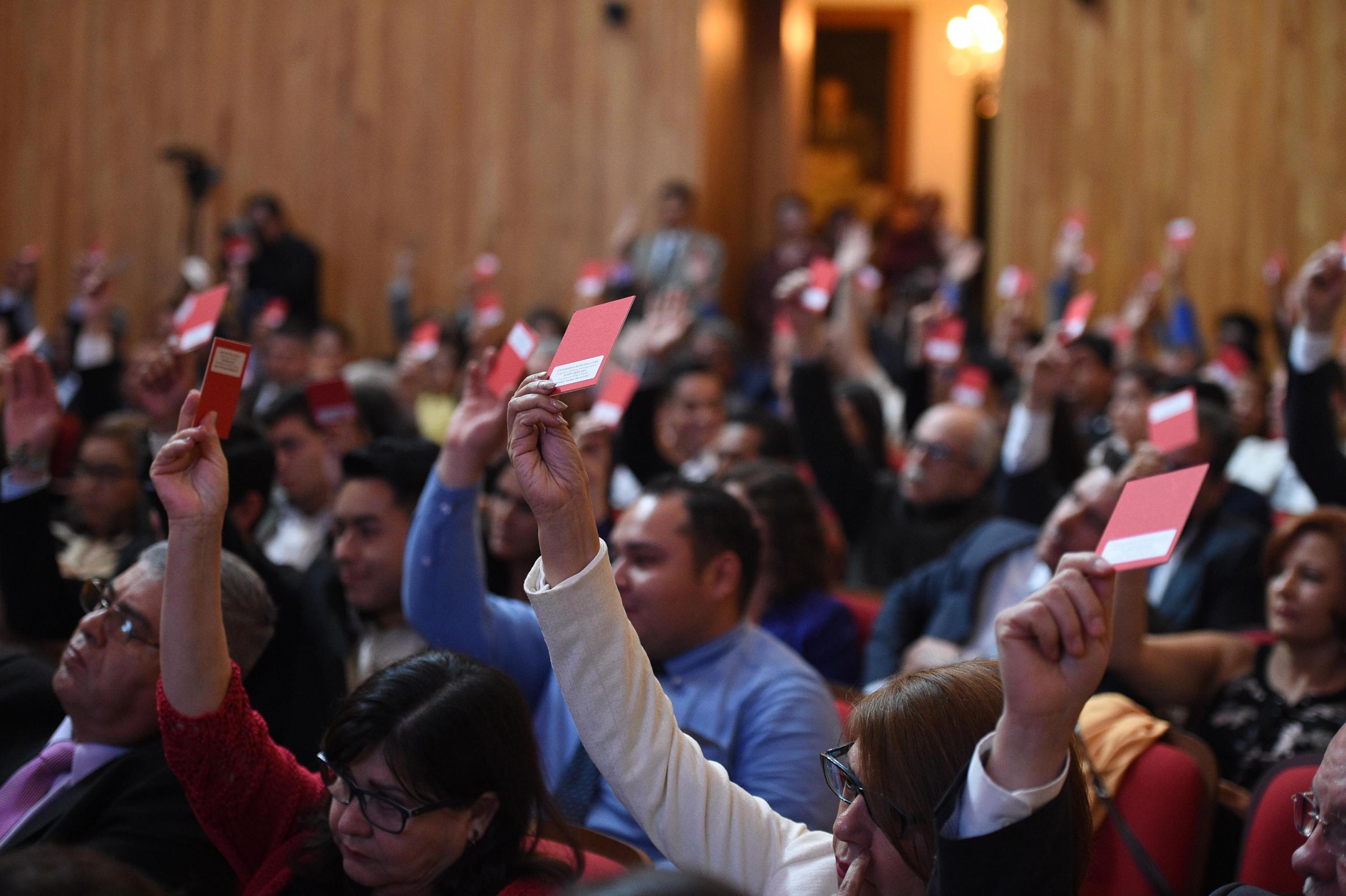 Miembros del Consejo General Universitario realizando su voto para la toma de decisiones.