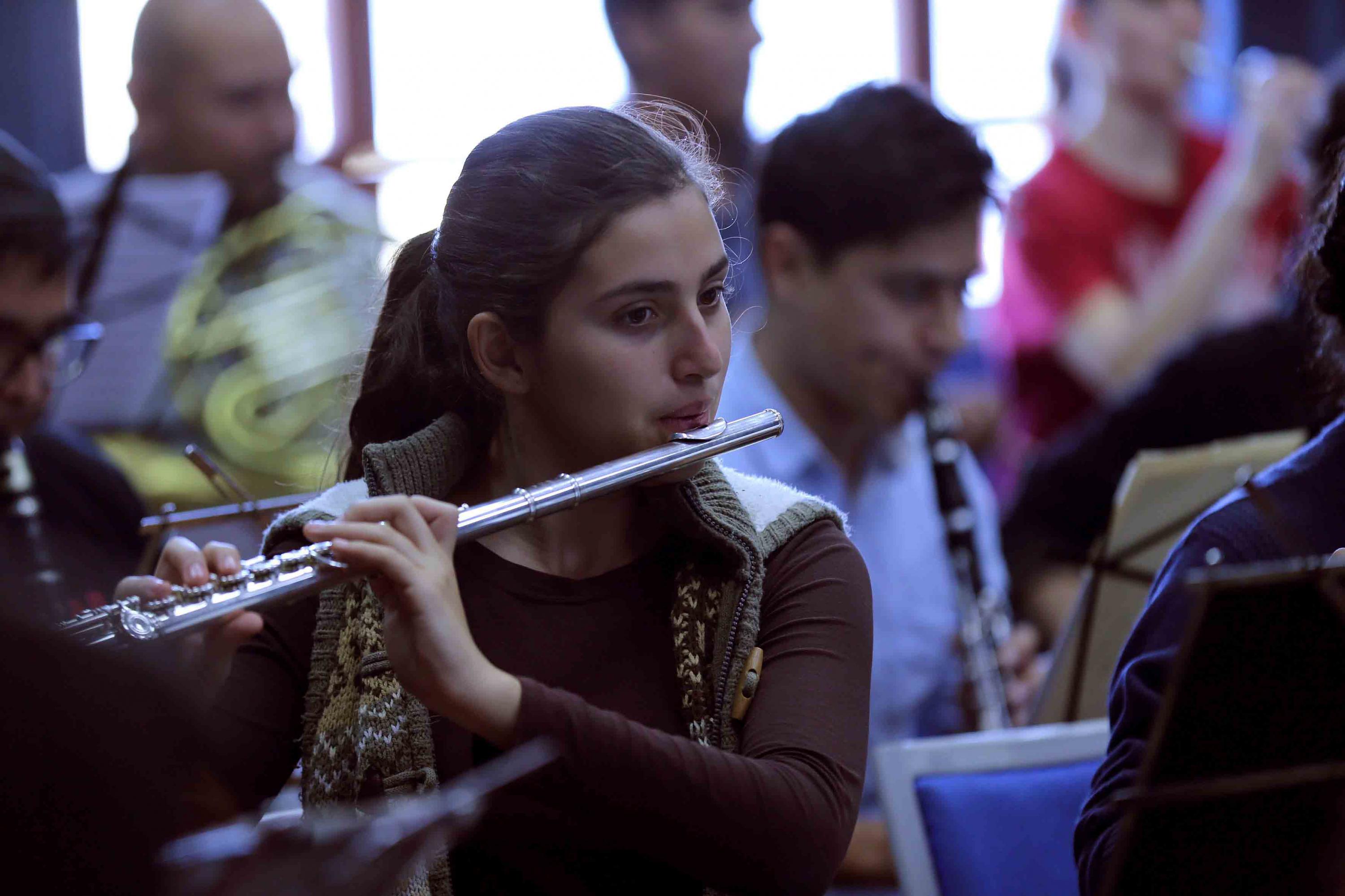 Una joven de la orquesta sinfonica tocando la flauta
