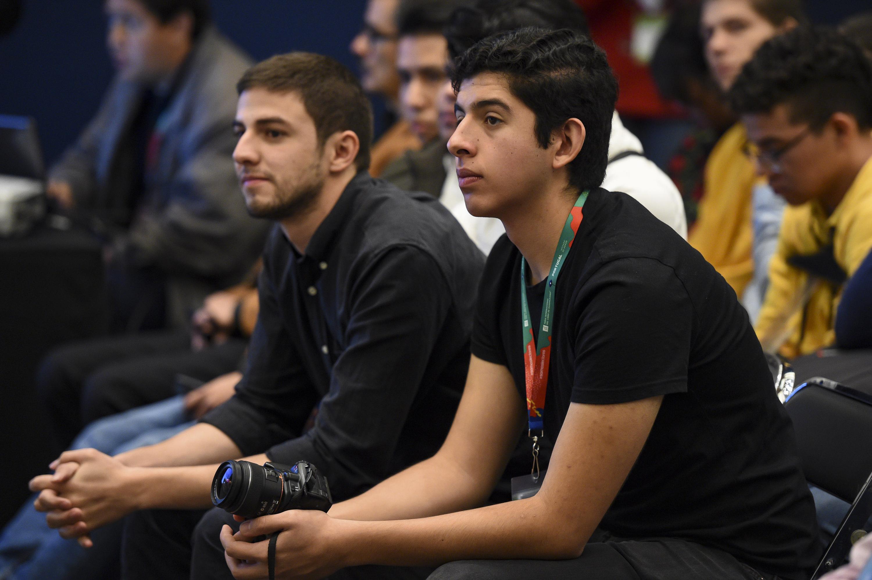 Dos jovenes escuchan atentos los resultados del concurso