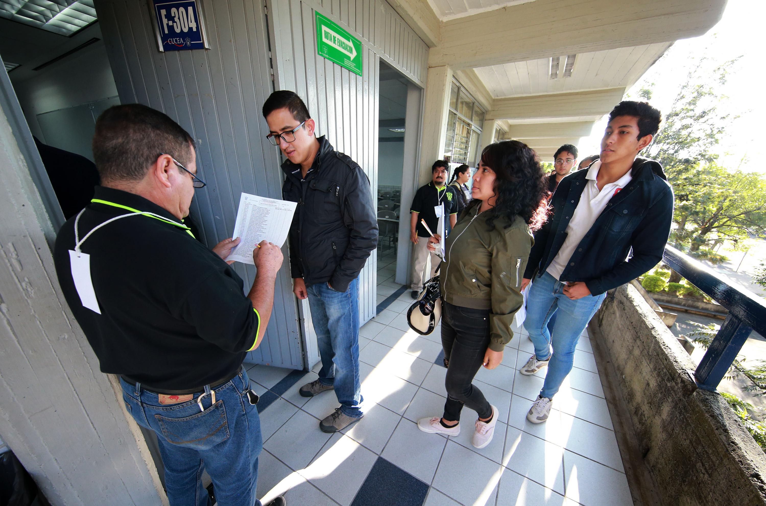 En la entrada de aulas, toman lista a los aspirantes para ingresar